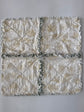 Quilt with leaf and bird pattern on a plain background