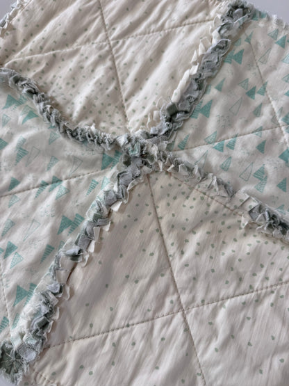 Close-up of a quilt with ruffled edge and geometric pattern