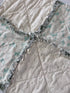 Close-up of a quilt with ruffled edge and geometric pattern