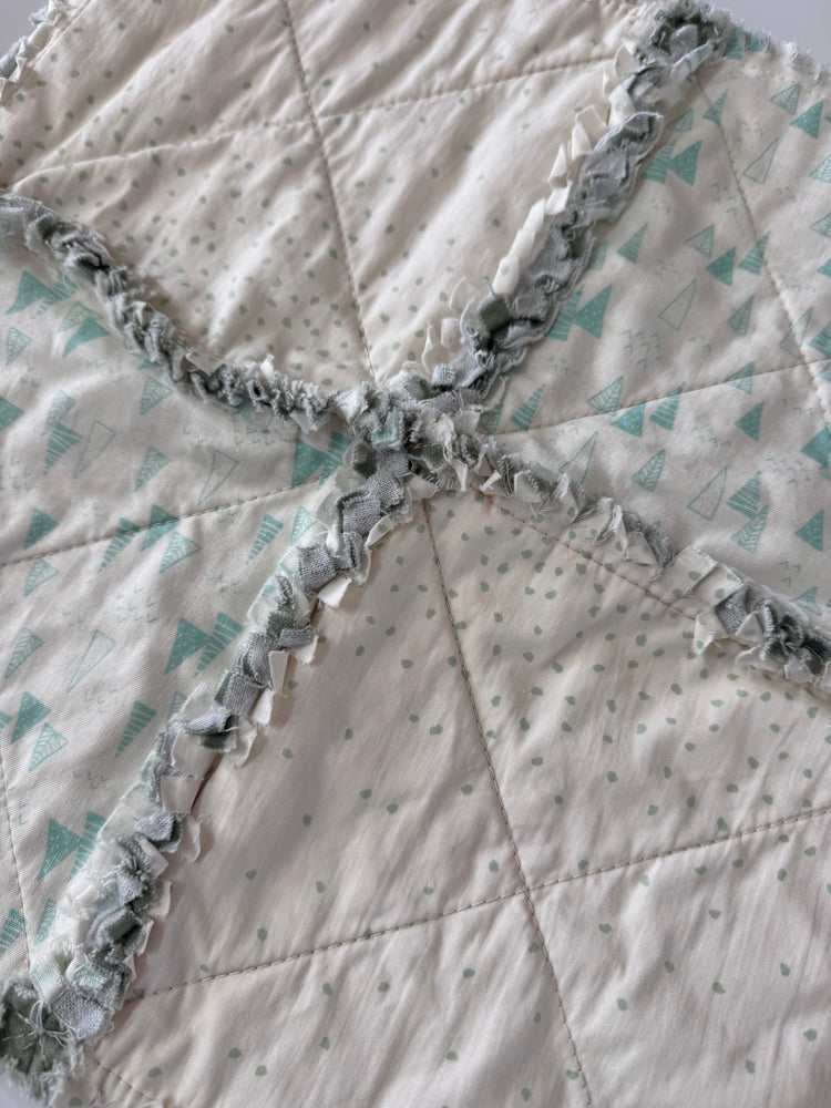 Close-up of a quilt with ruffled edge and geometric pattern