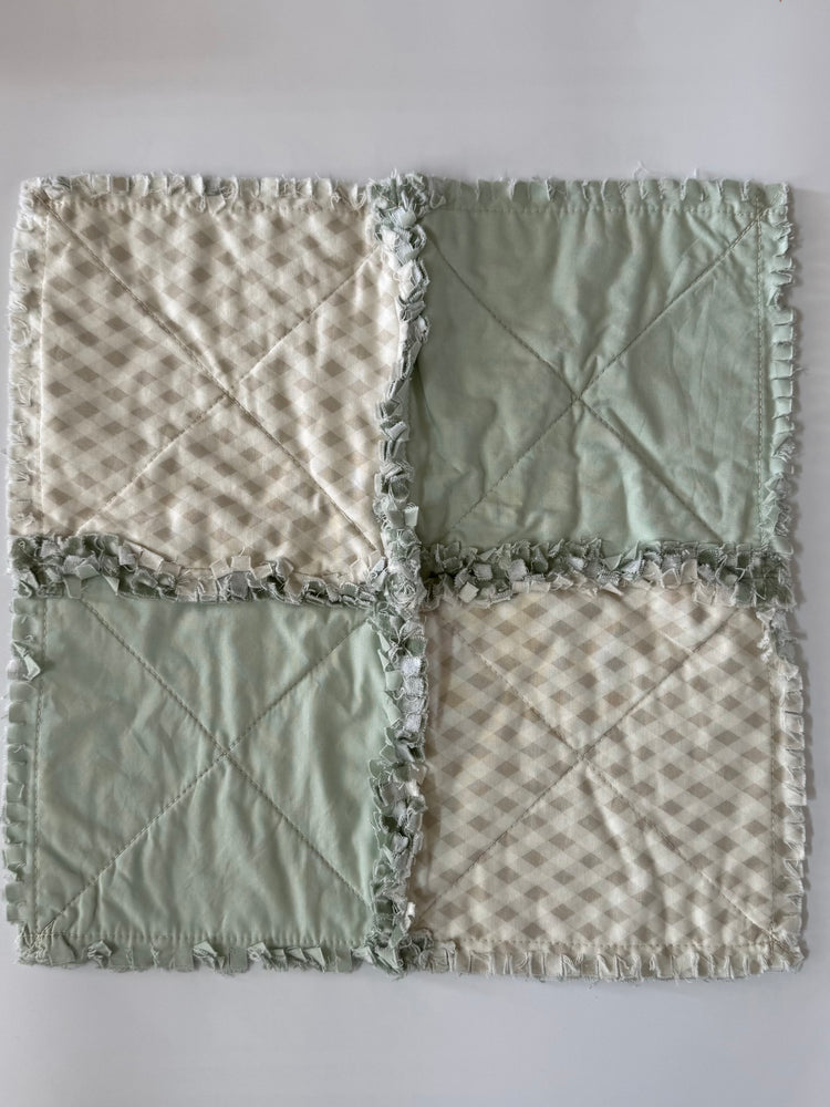 Fabric patchwork quilt with four square sections on a white background