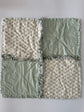 Fabric patchwork quilt with four square sections on a white background
