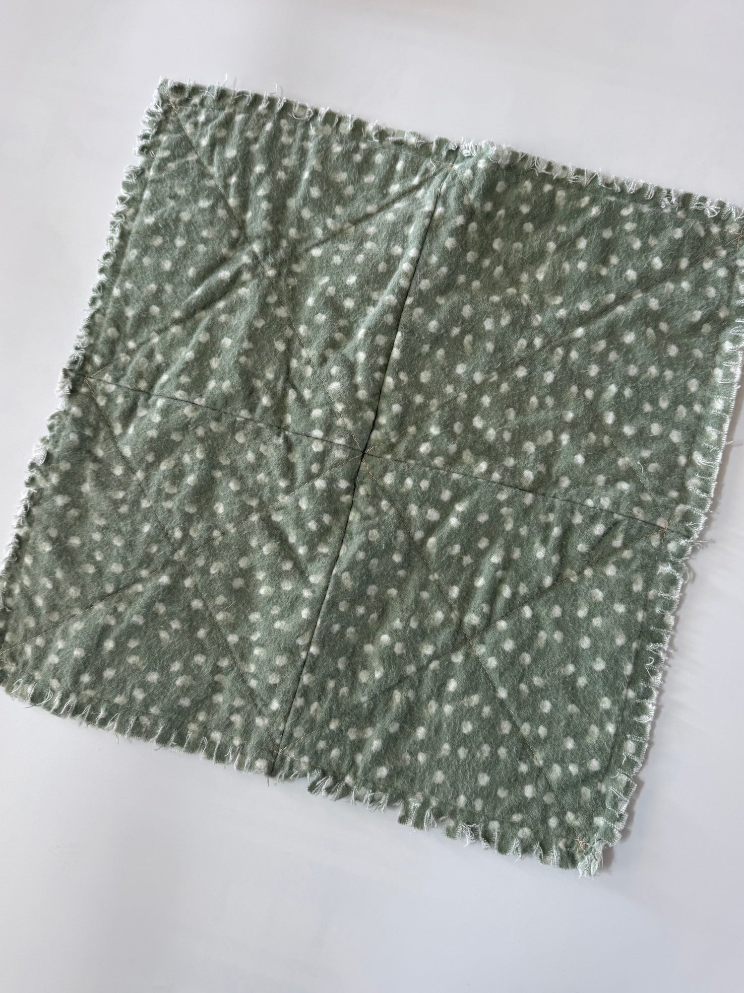 Green fabric with white pattern on a white background