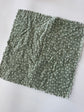 Green fabric with white pattern on a white background