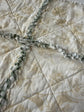 Close-up of a quilt with leaf and bird patterns. 