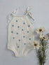 White infant romper with light blue daisy’s. Straps that tie at the top. Buttons at the crotch. 